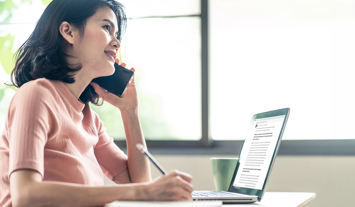 Woman conducting a telephone interview and recording survey responses on a laptop for a CATI data collection service UAE.