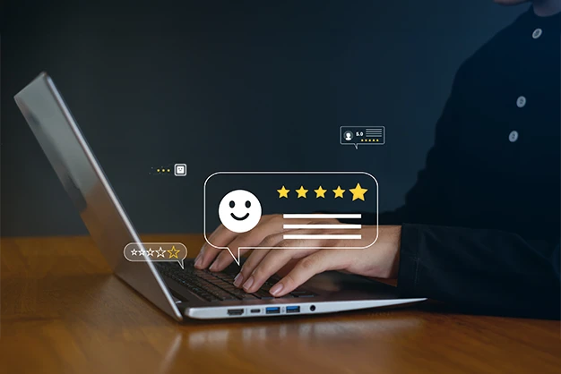 A side view of hands typing on a laptop keyboard with a digital graphic of a smiley face and a five-star rating, showcasing customer feedback and review-driven survey services in the UAE.