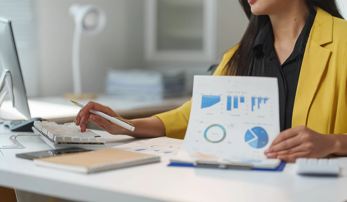 Business analyst reviewing customer insights and reports for a net promoter survey in a modern office